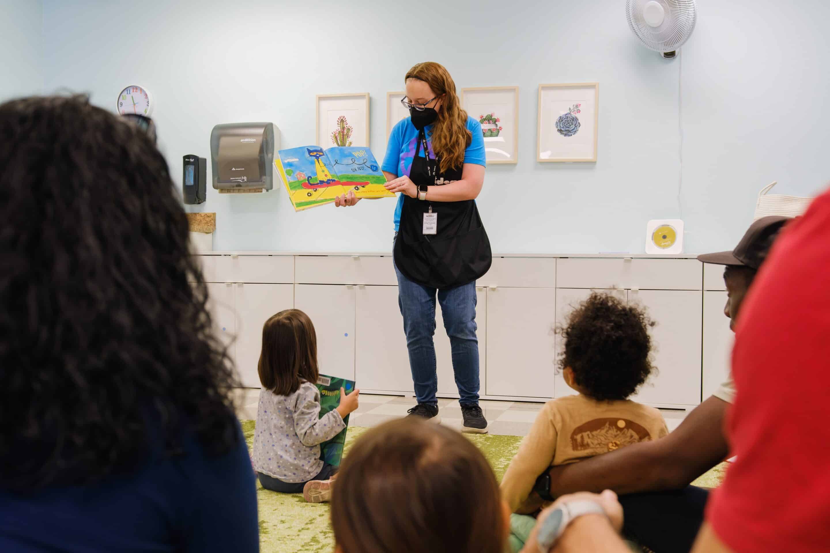 woman reading to children and their adults
